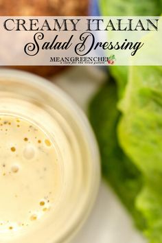 a creamy italian salad dressing in a small glass jar next to lettuce and tomatoes