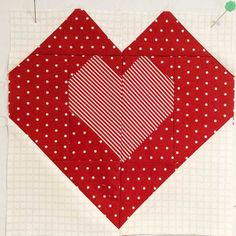 a red heart with white polka dots is on a piece of fabric that has been stitched together