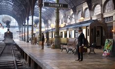 a train station with a man standing on the platform