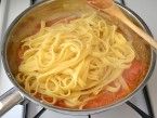 some noodles are being cooked in a pan on the stove