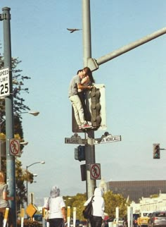 a man sitting on top of a traffic light