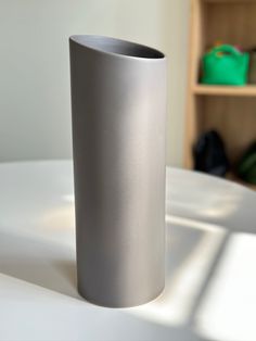 a silver vase sitting on top of a white table