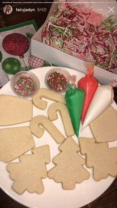 gingerbread cut out shapes on a plate with candy canes and other holiday treats