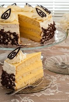 two slices of cake with white frosting and chocolate chips on top sitting on a glass platter