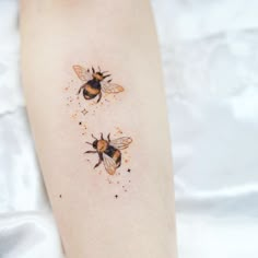 two honeybees on the left side of the right arm, with tiny stars around them