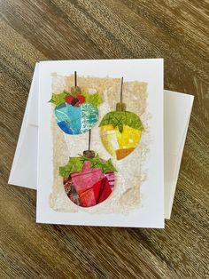 an ornament made out of colored paper on top of a wooden table next to a card