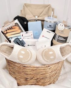 a basket filled with lots of items on top of a white blanket next to a purse