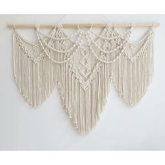 three macrame wall hangings on a white wall