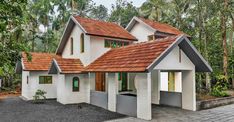 a white house with red tile roof and green windows