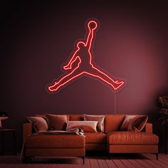 an air jordan neon sign hangs on the wall above a couch in a living room