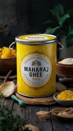 a can of maha ghee sitting on top of a wooden table next to spoons