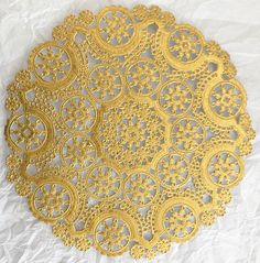 a yellow doily sitting on top of a white tablecloth covered in crochet