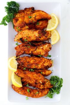 chicken wings with lemon wedges and parsley