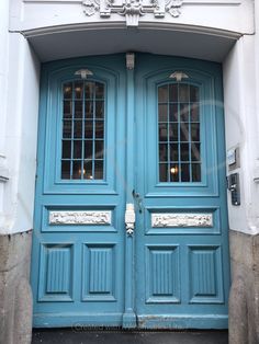 two blue doors are open in front of a white building