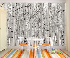 an image of a dining room setting with birch trees on the wall and striped rug