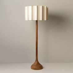 a lamp that is on top of a table next to a white wall and floor