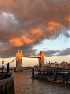 the tower bridge in london is lit up at sunset