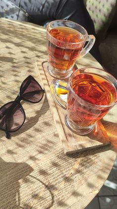 two glasses of tea sit on a table