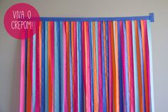 colorful streamers are hanging on the wall in front of a gray wall with a blue frame