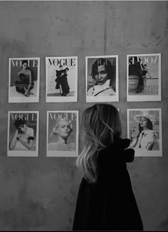 a woman standing in front of a wall with posters on it's sides and the words voicie above her head