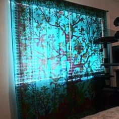 a bedroom with a window covered in green curtains