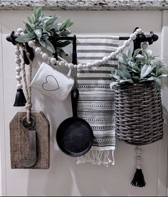 pots and pans are hanging on the wall next to each other with plants in them