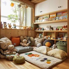 a room filled with lots of stuffed animals on top of pillows and rugs in front of a window