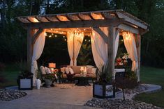 a gazebo with curtains and lights on it