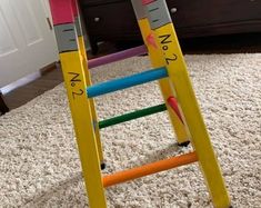 a child's wooden ladder sitting on top of a carpeted floor