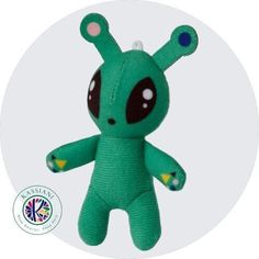 a green stuffed animal with big eyes and an ear tag on it's head