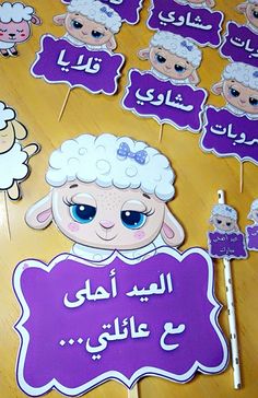 there are many sheep on the table with purple signs in arabic and english, along with stickers