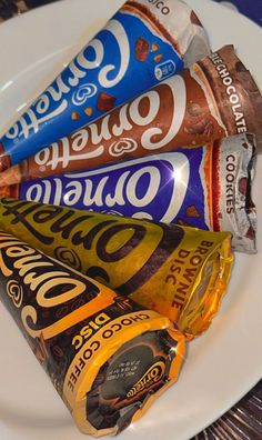 a white plate topped with three different types of chocolates and candy bar wrappers