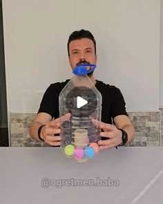 a man holding a large bottle with balls in it and an opening mouth to the water