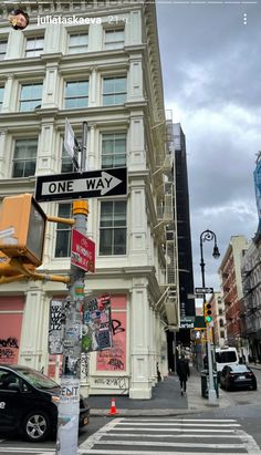 a one way street sign in front of a tall building