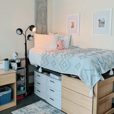 a bedroom with a bed, dressers and pictures on the wall next to it