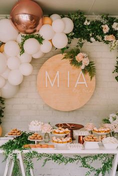 a table topped with lots of desserts next to a sign that says mia on it