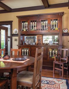 a wooden dining room table with chairs around it