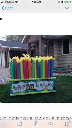 an image of a birthday cake made out of candles on the grass in front of a house