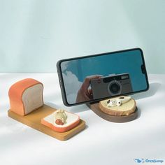 a cell phone with a camera on it next to slices of bread and a piece of bread