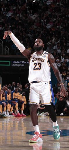 a basketball player in action on the court with his arms out and hands extended up