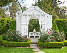 a white gazebo sitting in the middle of a garden