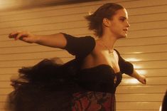 a woman in a black dress is dancing