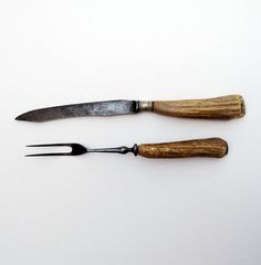 two knives with wooden handles on white surface