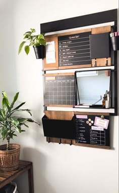 a black and white wall mounted on the side of a wall next to a potted plant