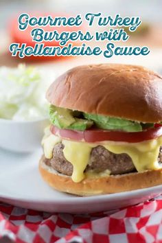 a cheeseburger with lettuce, tomatoes and onions on a white plate