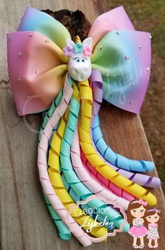 a rainbow colored bow with a unicorn head on it and other bows around the top