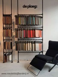 a black chair sitting in front of a tall book shelf filled with lots of books