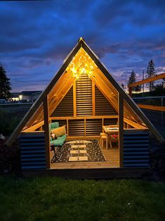 a small wooden cabin sitting on top of a lush green field