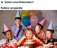 a group of children sitting around a table with a cake and candles in front of them