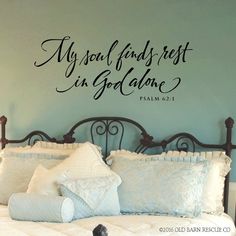 a bedroom with a bed and wall decal that says, my soul finds rest in god alone